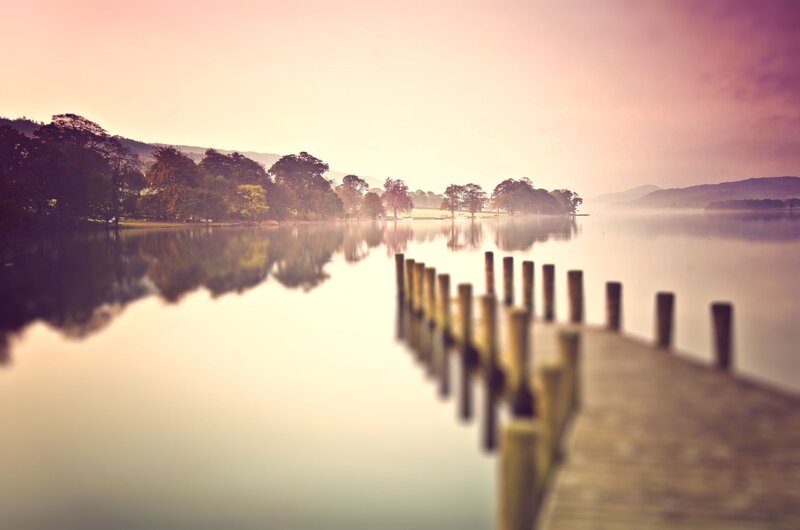 Pier on a misty lake at dawn