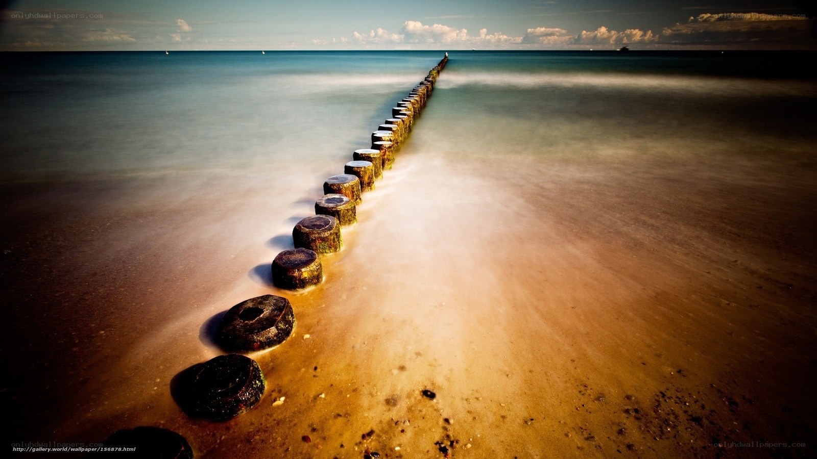 Pier on the beach at sunset