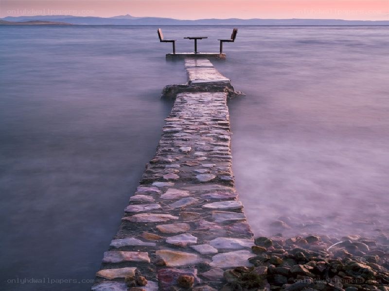Pier with bench at sunset
