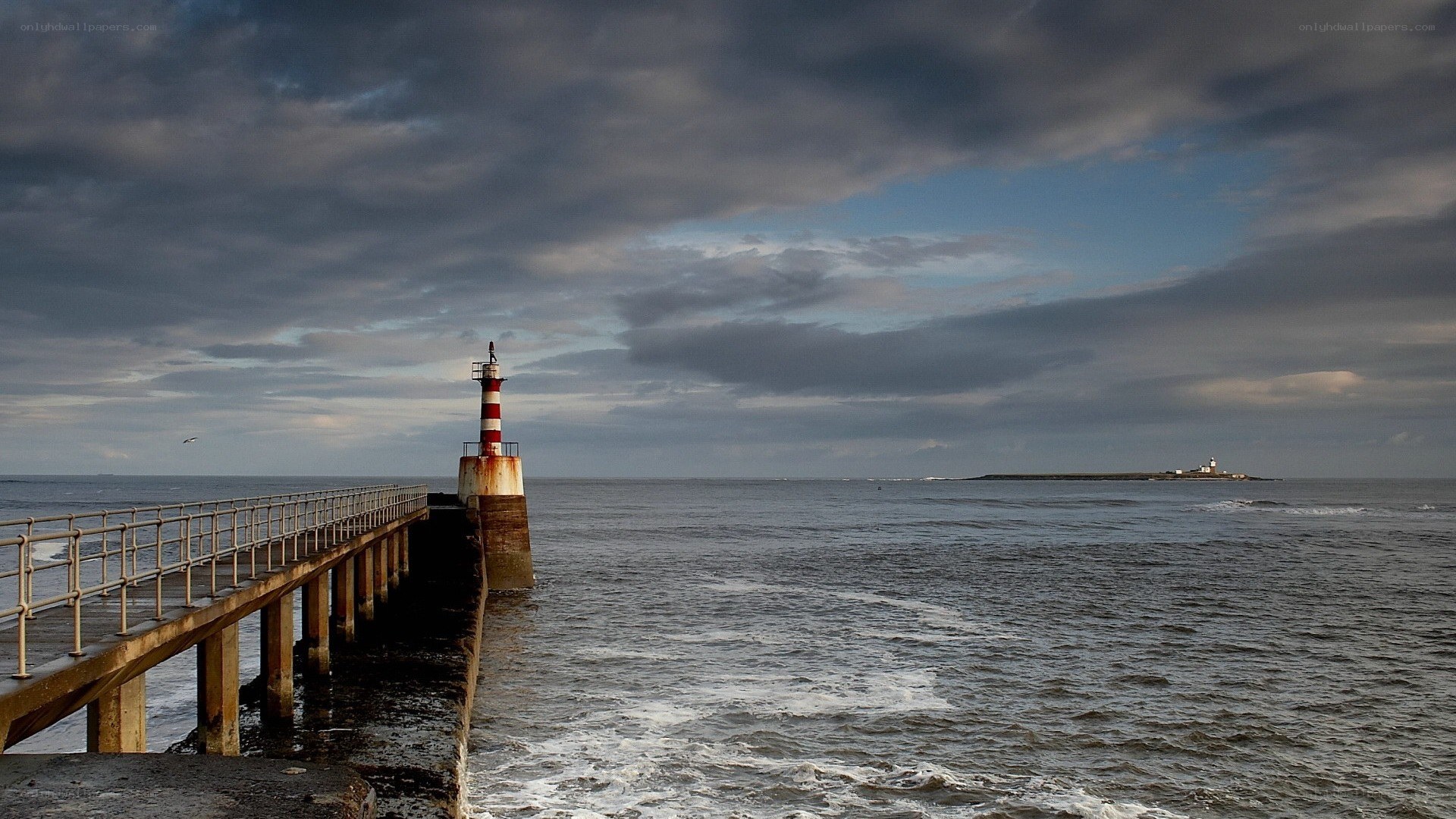 Pier with lighthouse at sea