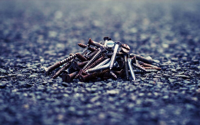 pile of screws on asphalt