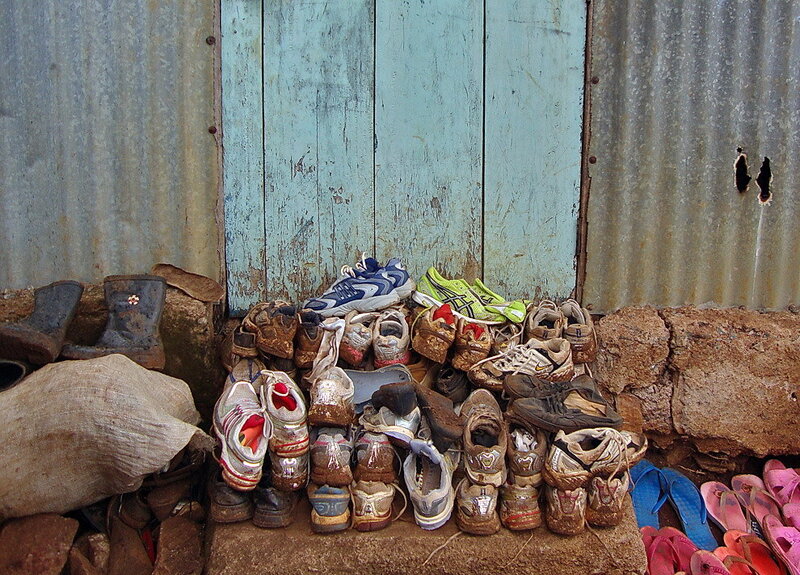 Pile of worn shoes against a wall