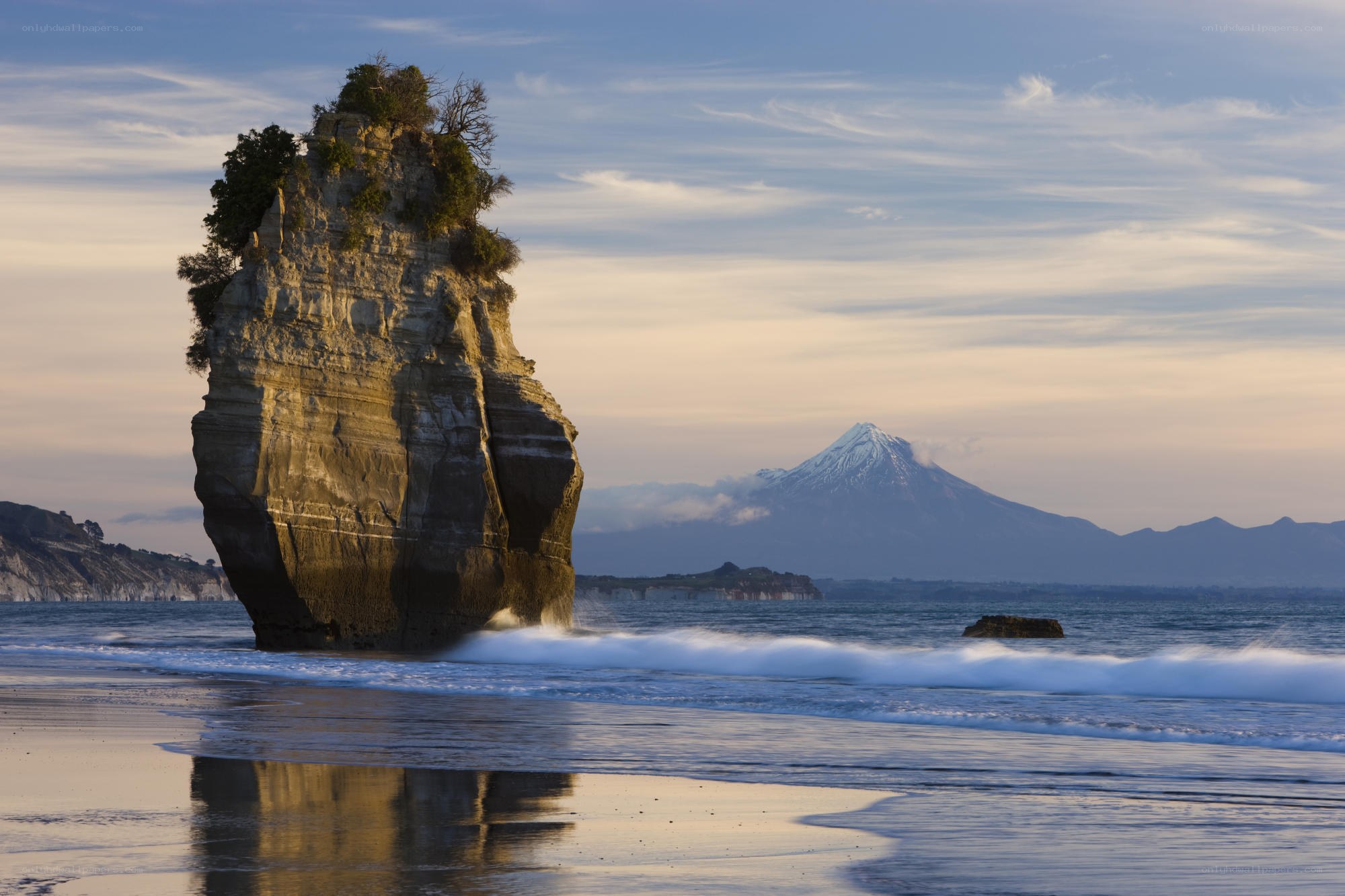 Pillar rock at beach with mountain