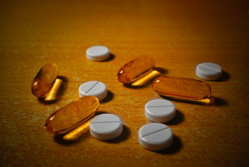 pills and capsules on wood