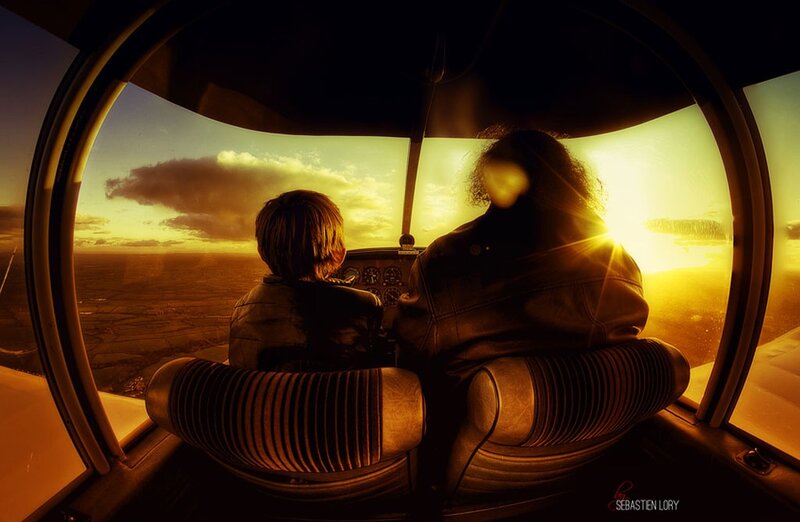 Pilot and child in cockpit at sunset