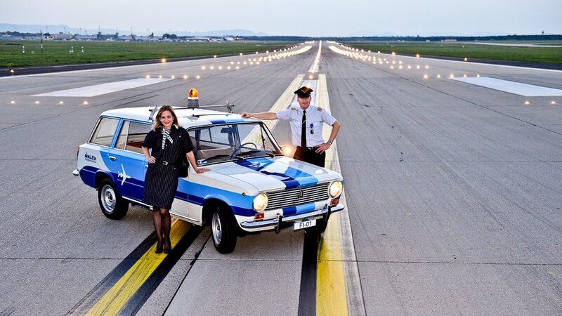 Pilot and flight attendant with vintage car