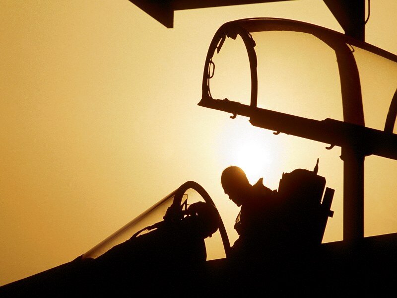 Pilot in cockpit at sunset