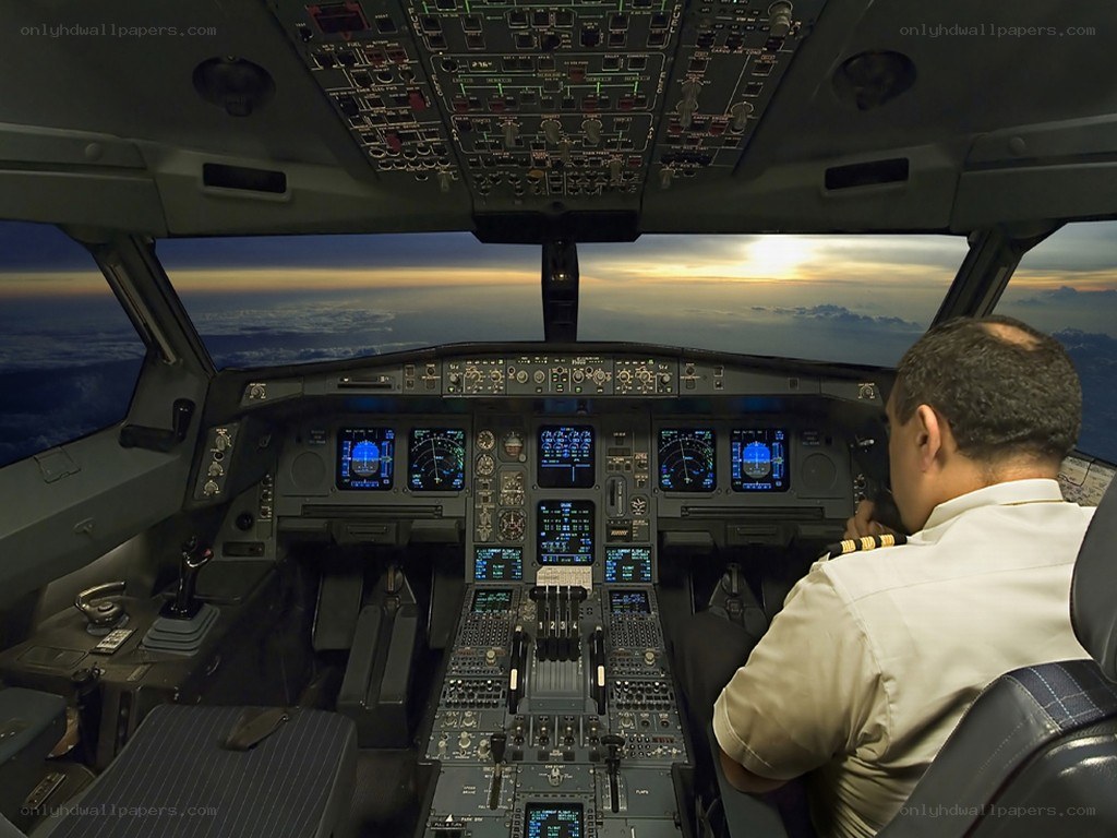 Pilot in cockpit at sunset