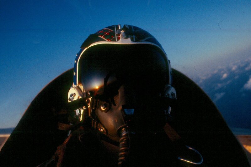 pilot in cockpit at sunset