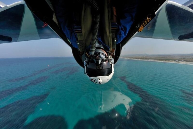 Pilot in cockpit over ocean