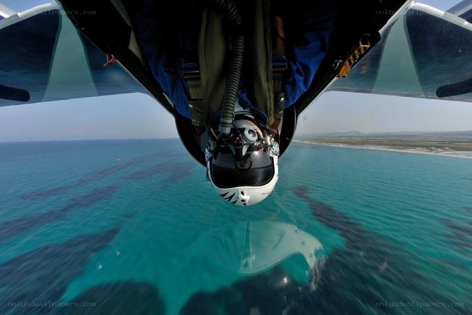 Pilot in cockpit over ocean