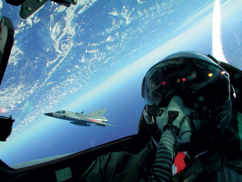 Pilot in cockpit with fighter jet