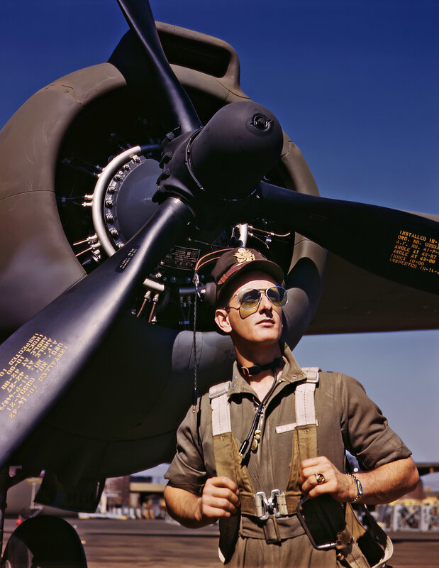 Pilot standing by aircraft propeller
