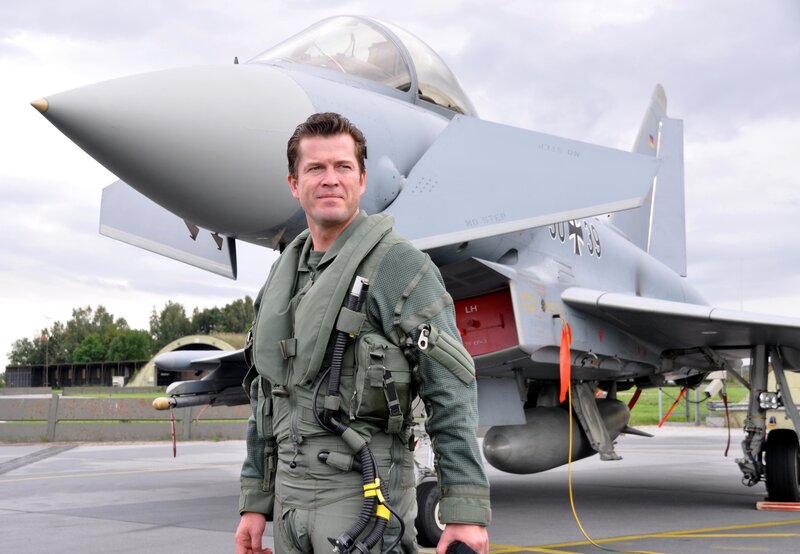 Pilot standing in front of fighter jet