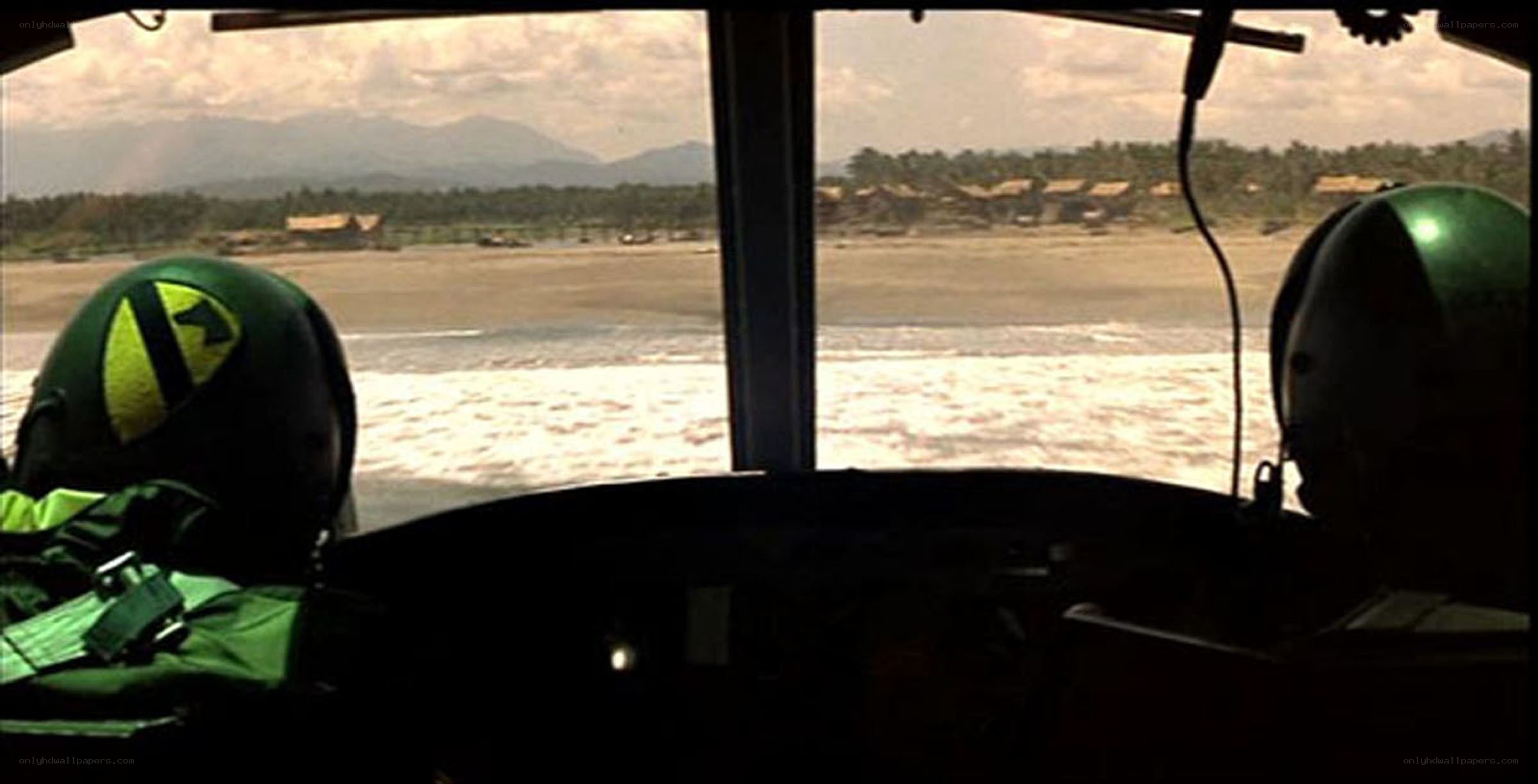 Pilots in cockpit over beach