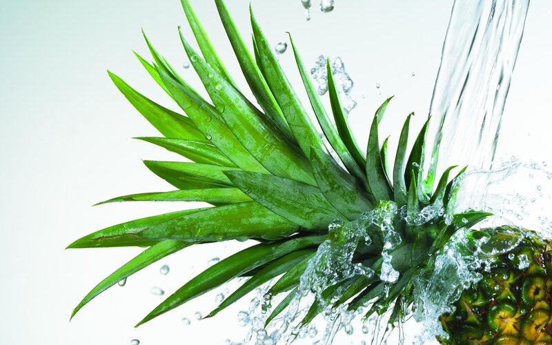 pineapple being washed with water