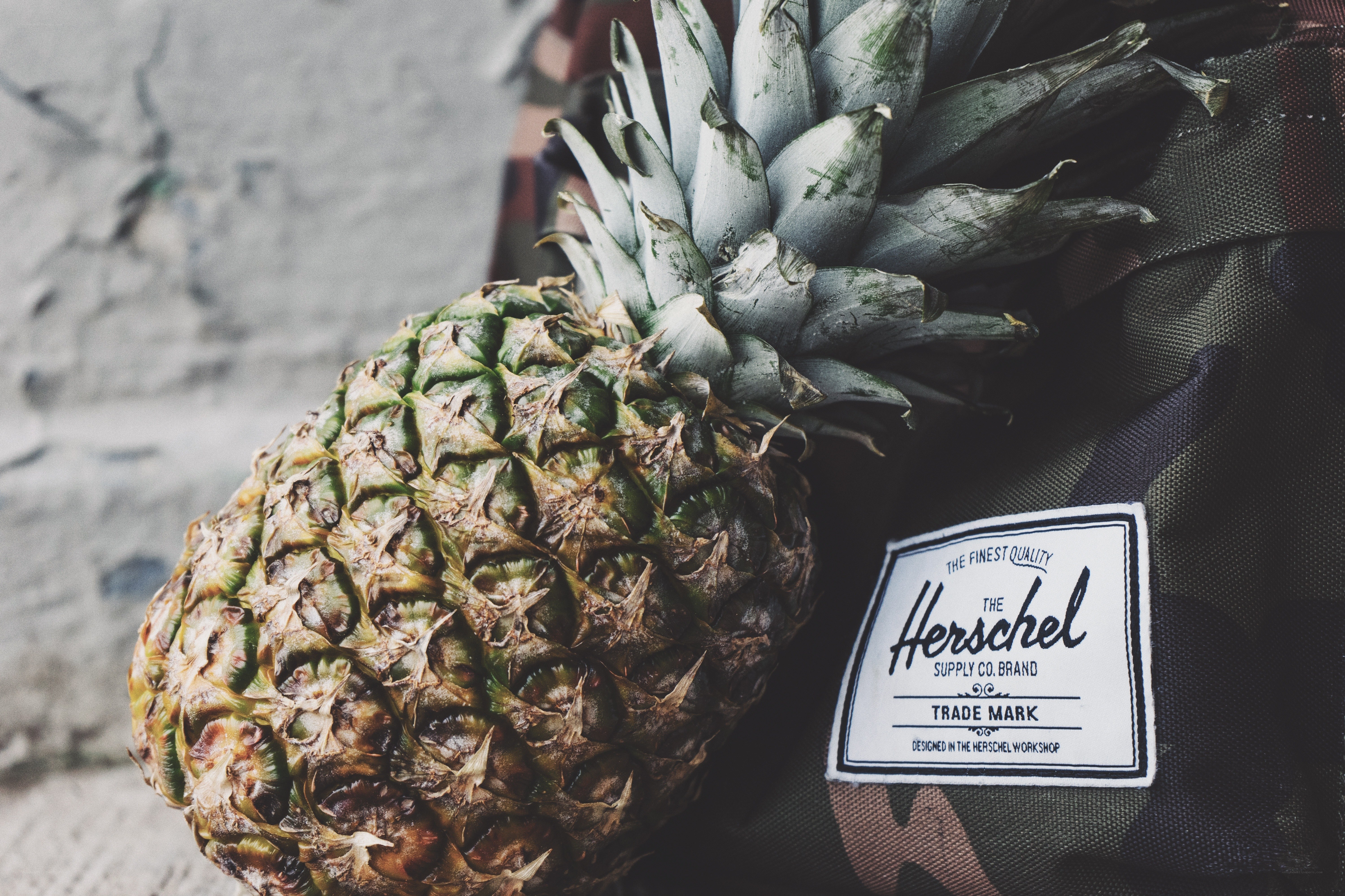 pineapple next to Herschel bag