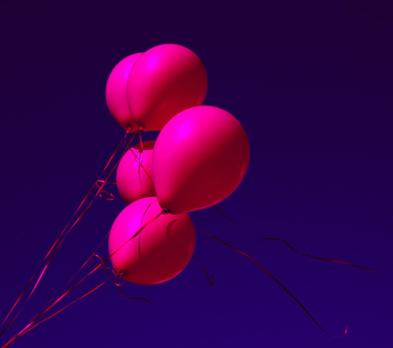 pink balloons floating in purple