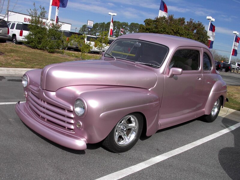 Pink classic car in parking lot