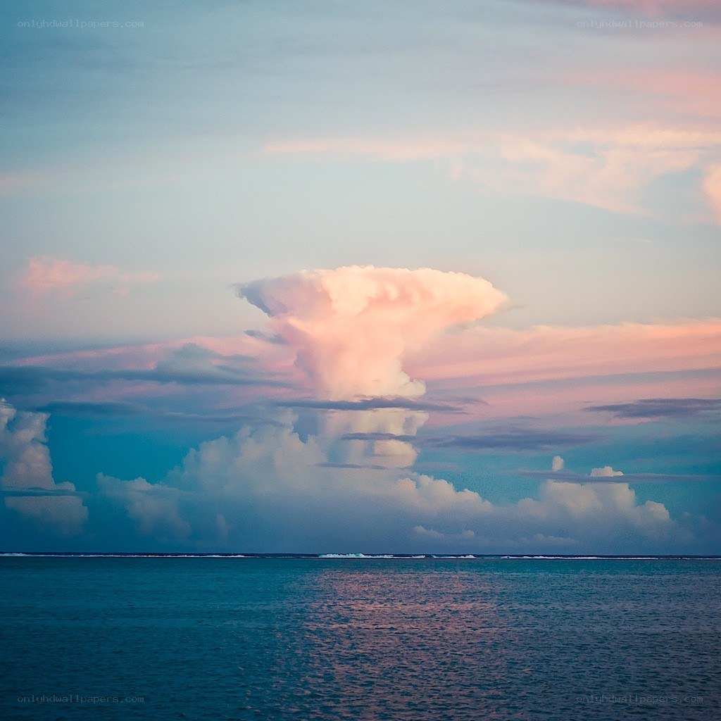 Pink cloud over ocean at sunset