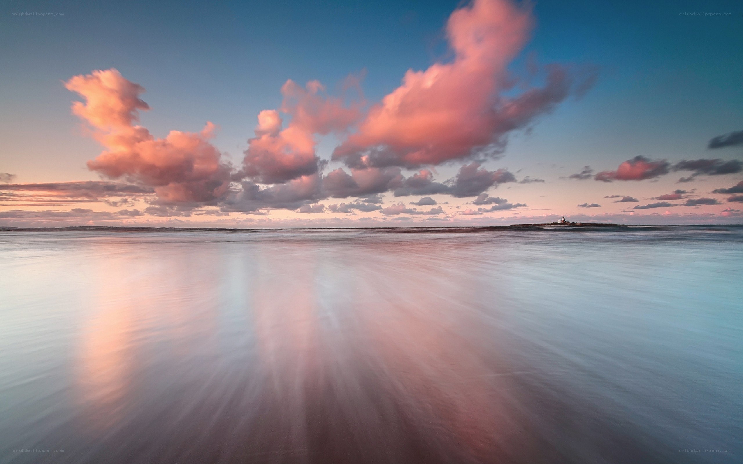 Pink clouds over calm sea