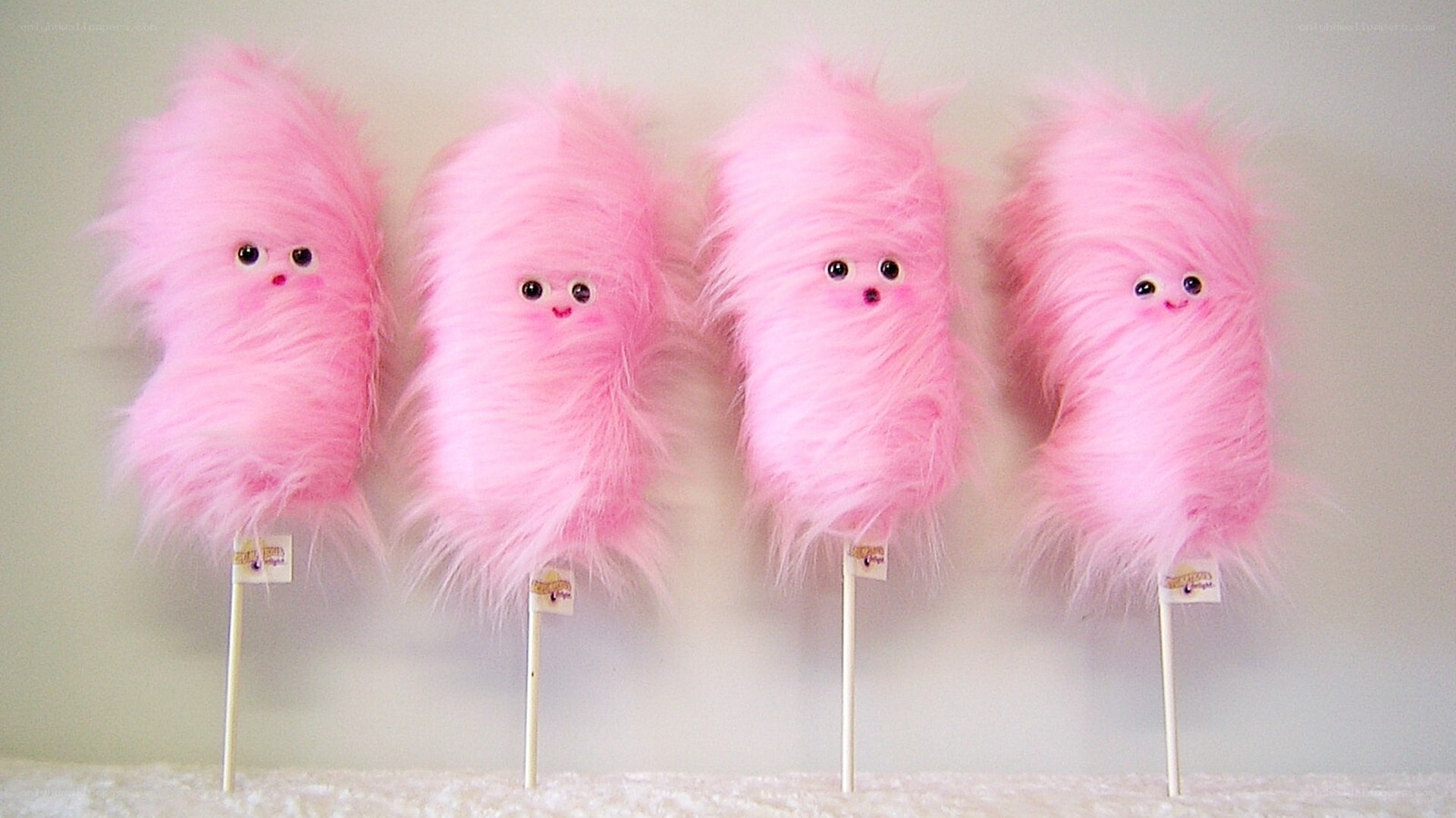 pink fluffy monsters on sticks