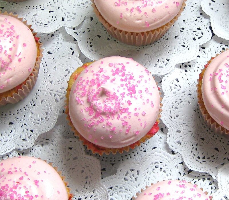 Pink-frosted cupcakes on doilies