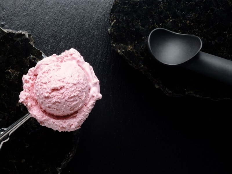 Pink ice cream scoop on black stone