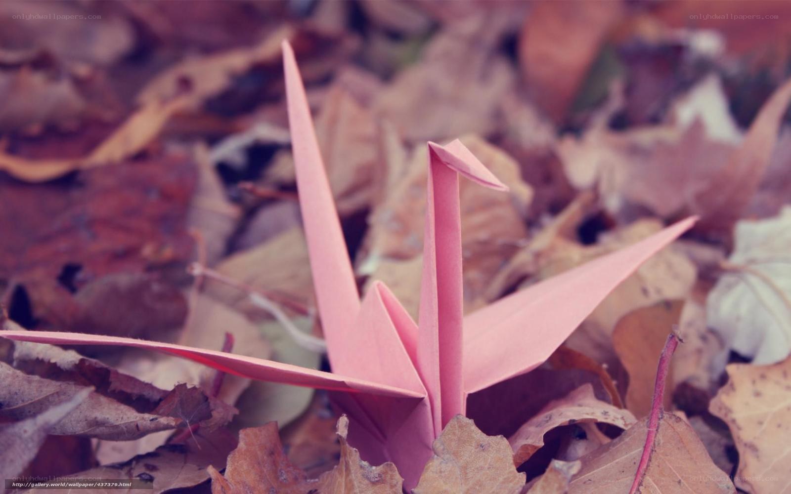 Pink origami crane in autumn leaves