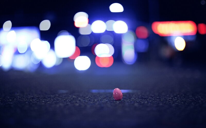 Pink pill on asphalt at night