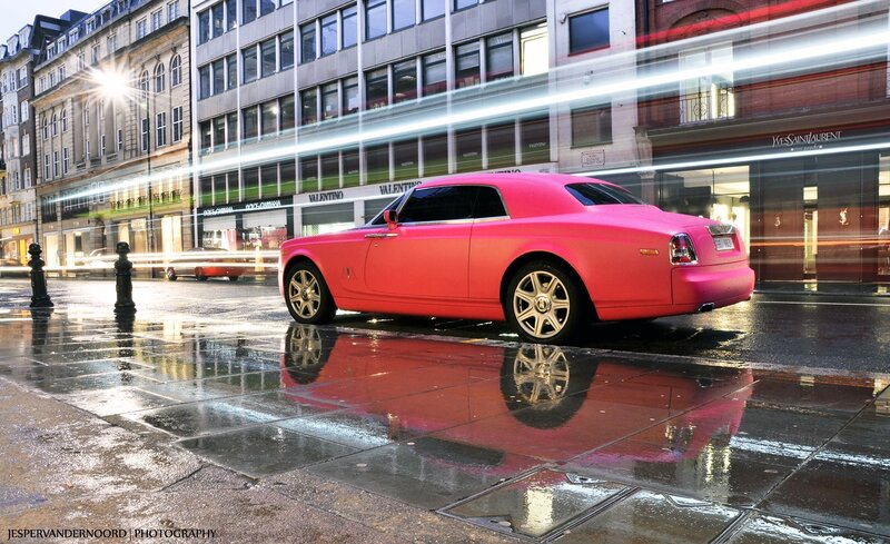 Pink Rolls-Royce on wet city street