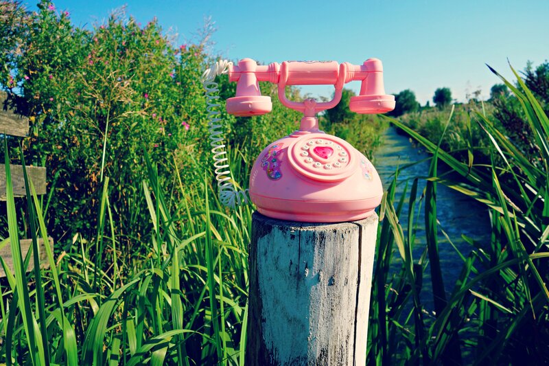 Pink rotary phone on a post