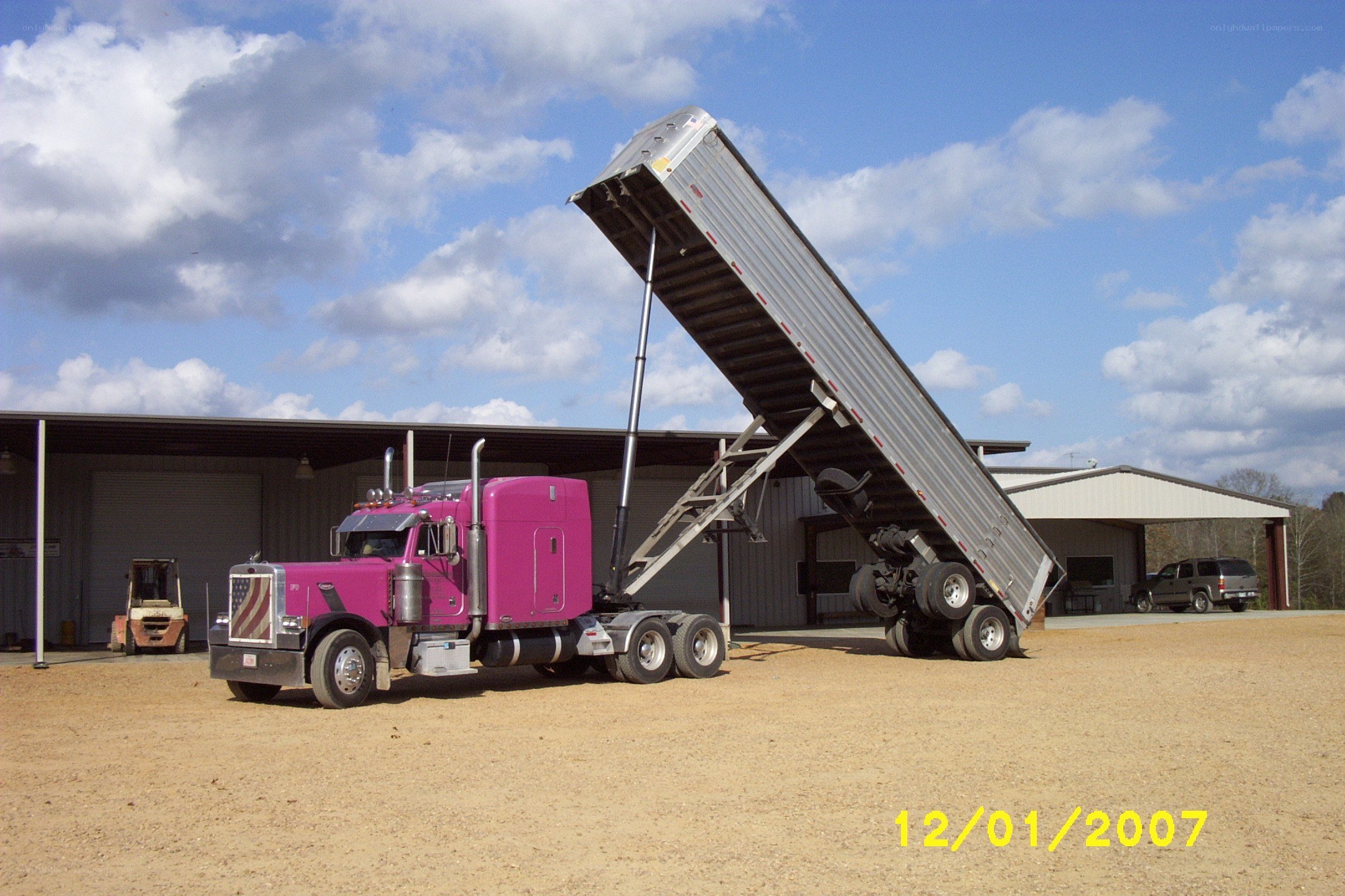 Pink semi-truck dumping cargo
