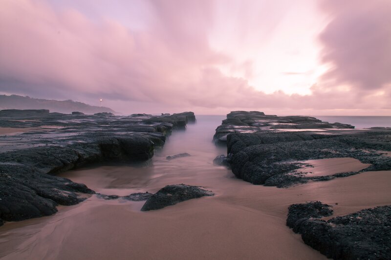 Pink sky at coastal rocks