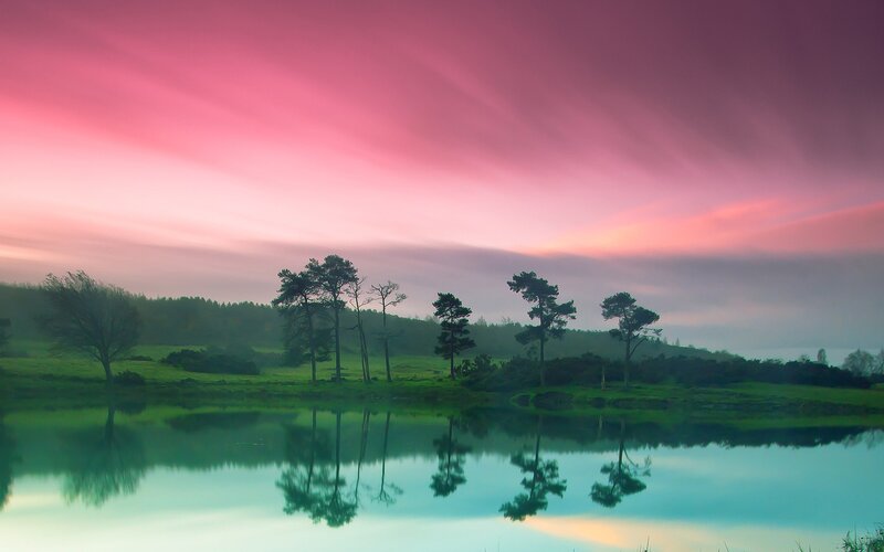 Pink sky over lake at dawn