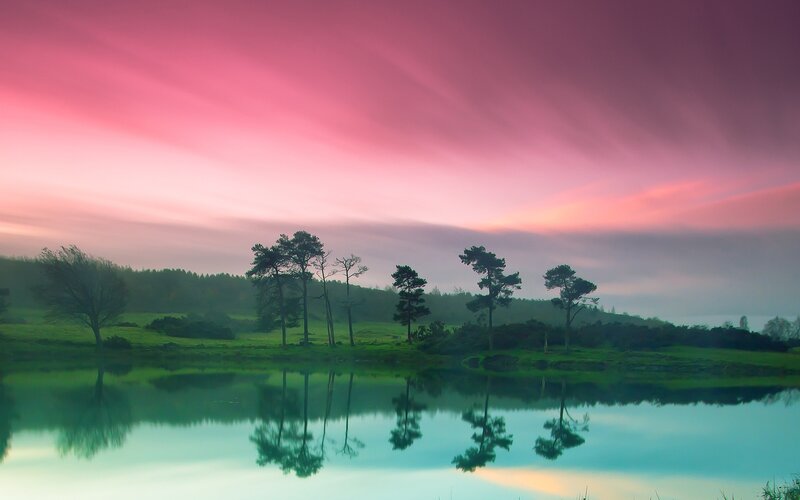 Pink sky over lake at dawn