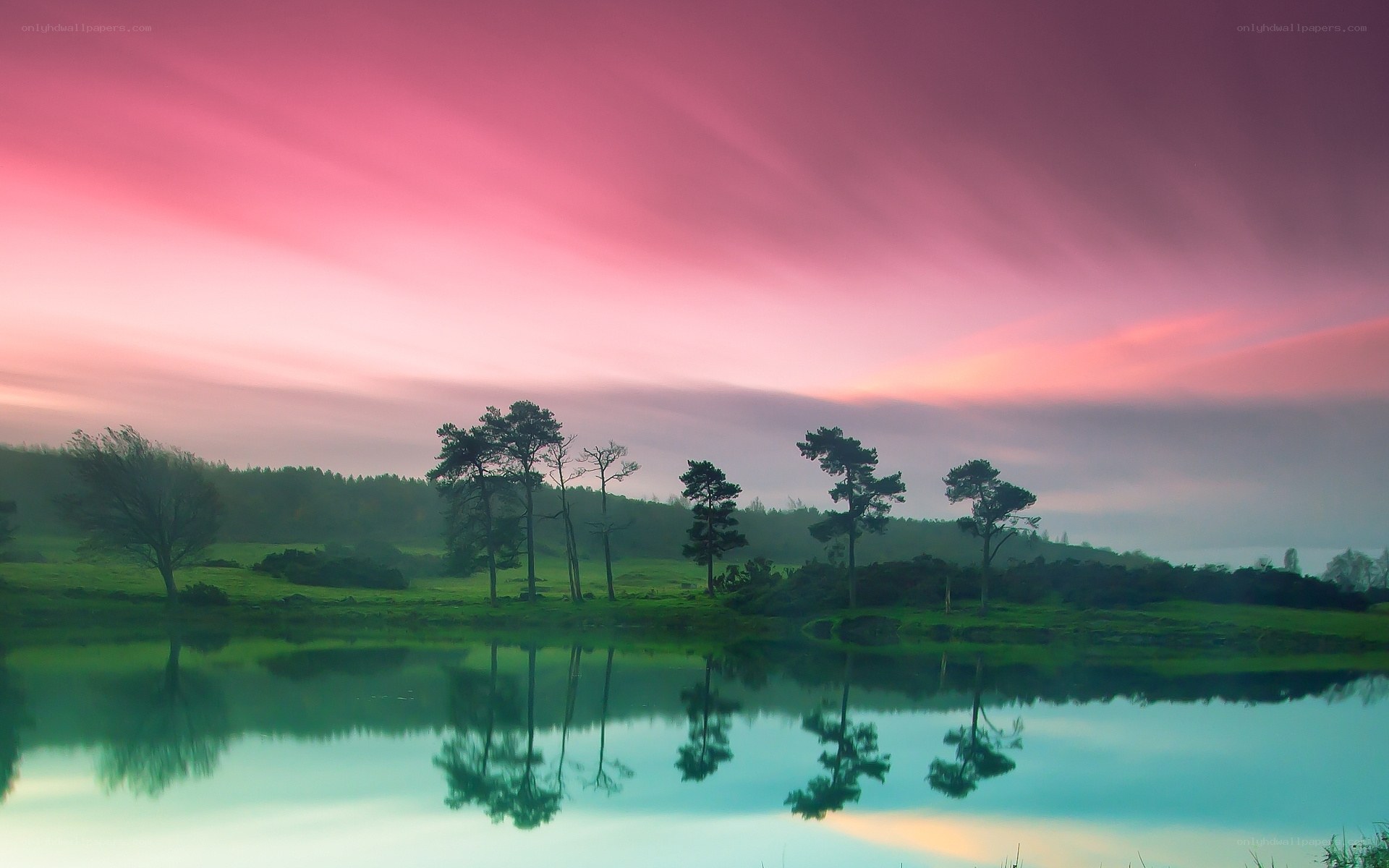 Pink sky over lake at dawn