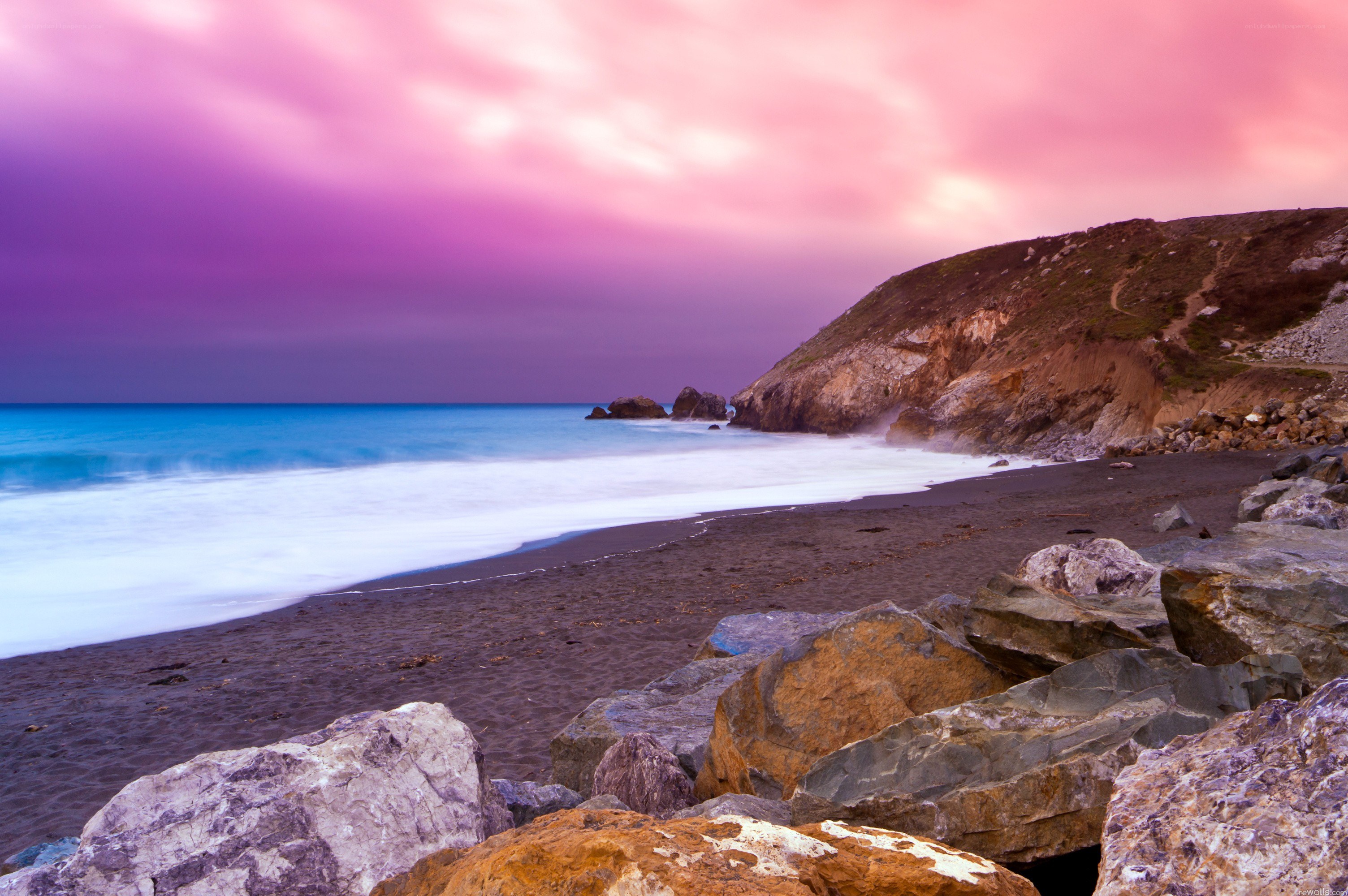 Pink sky over rocky beach