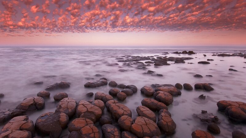 Pink sky over rocky shore