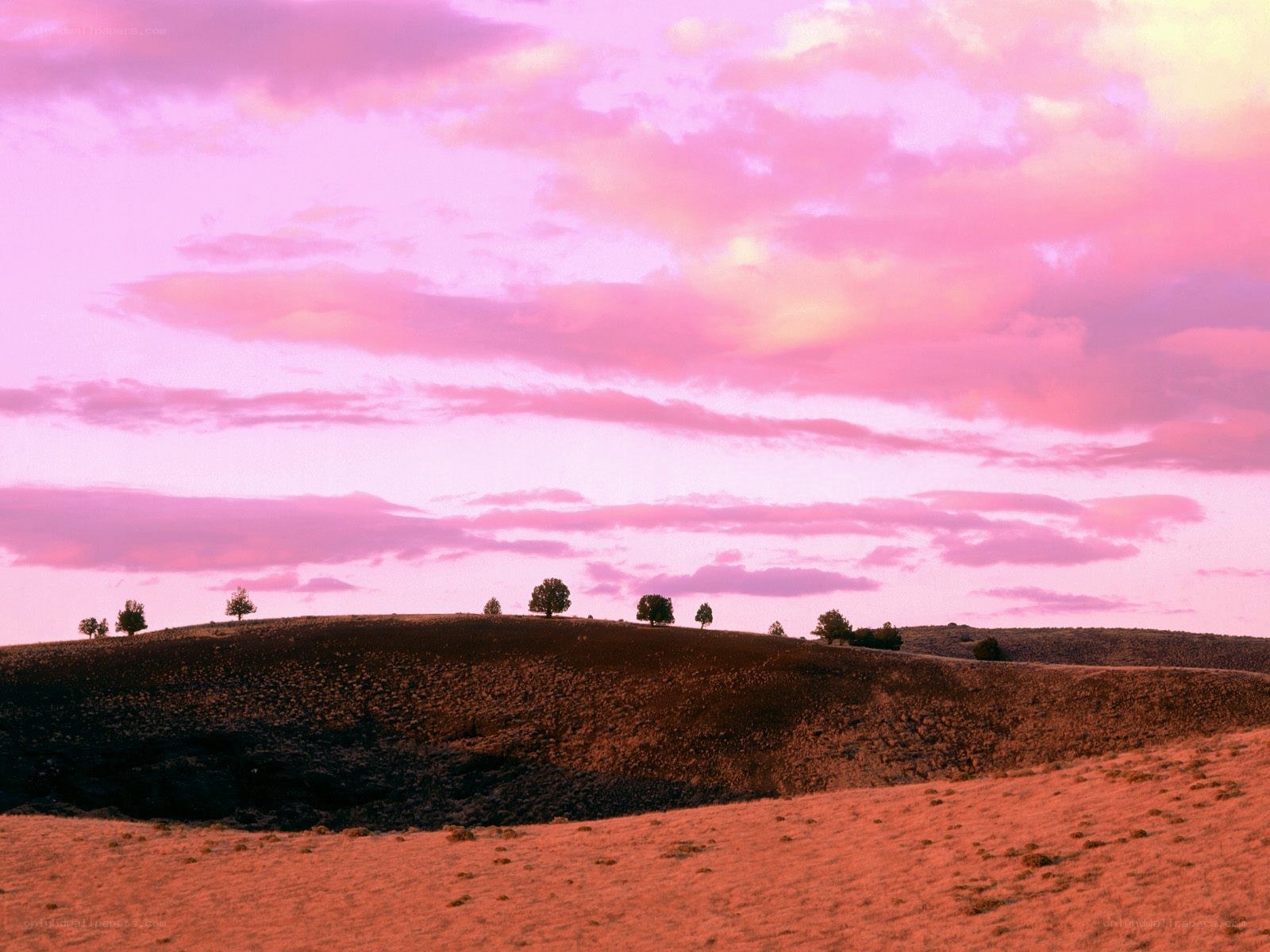Pink sky over rolling hills
