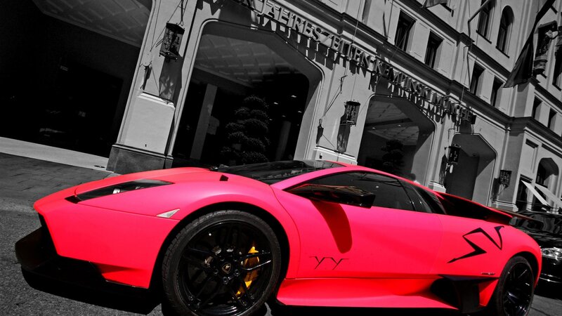 pink sports car in front of hotel
