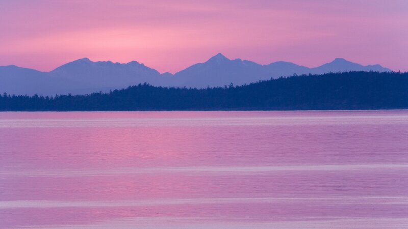Pink sunset over mountains and water
