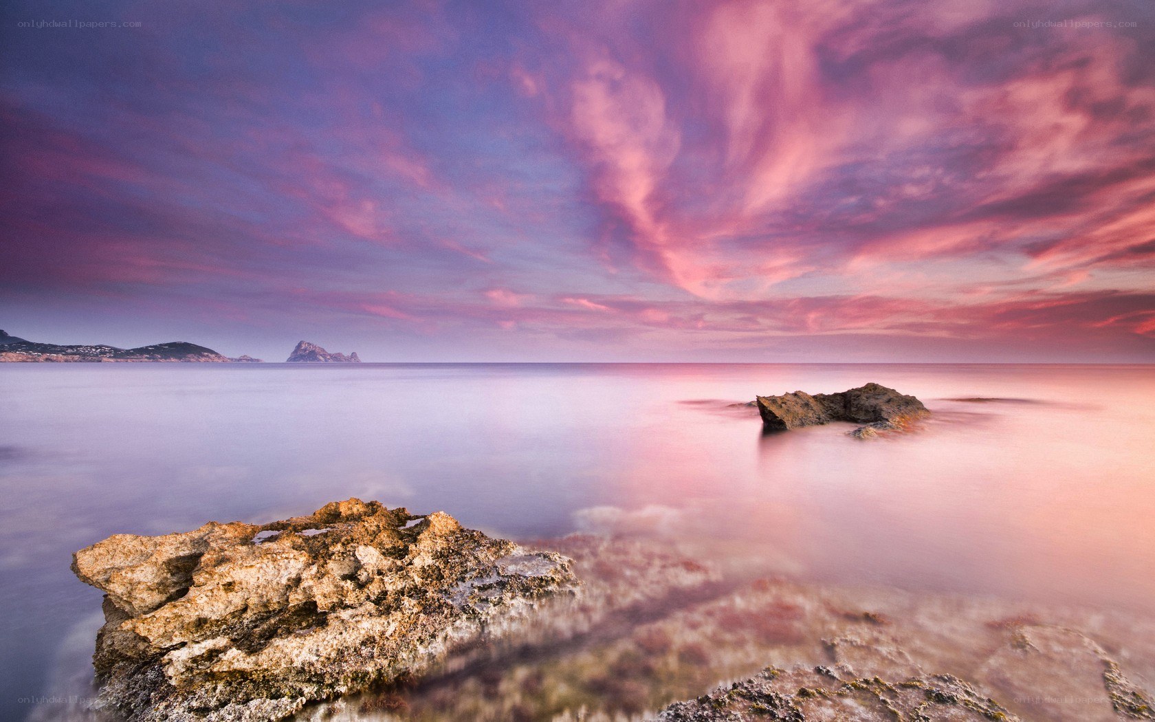 Pink sunset over rocky coastline