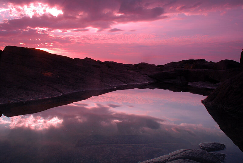 Pink sunset over rocky pool