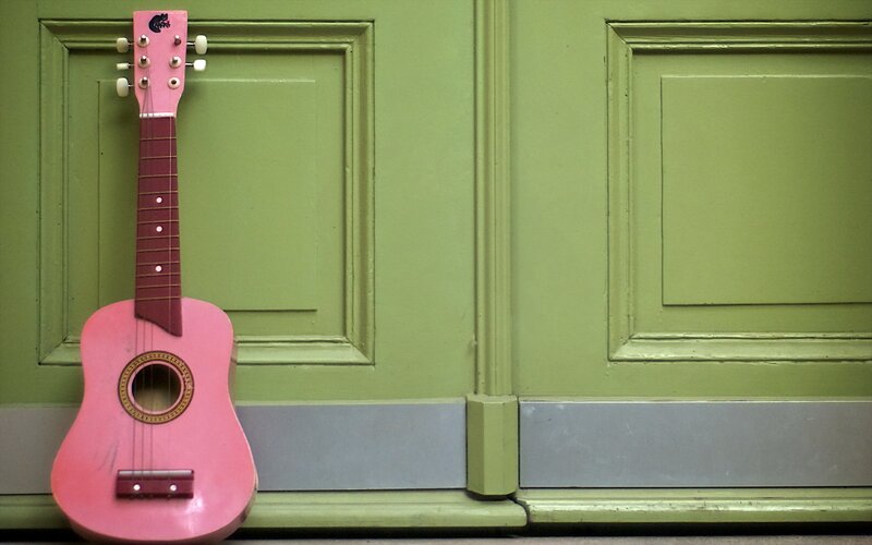 Pink Ukulele Against Door