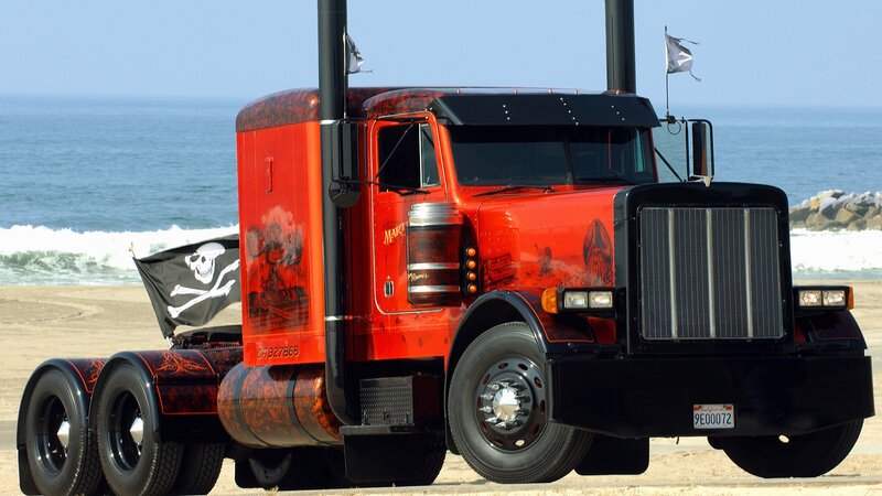 Pirate-themed red semi-truck on beach