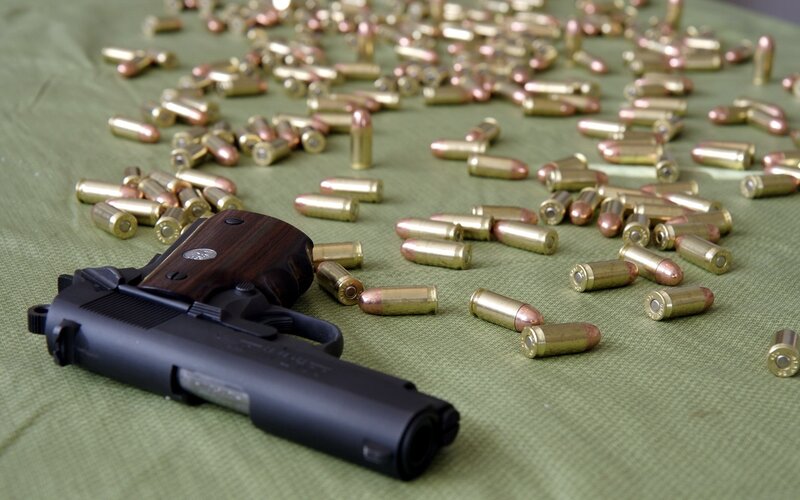 Pistol and ammunition on green cloth