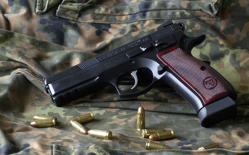 pistol with ammunition on camouflage