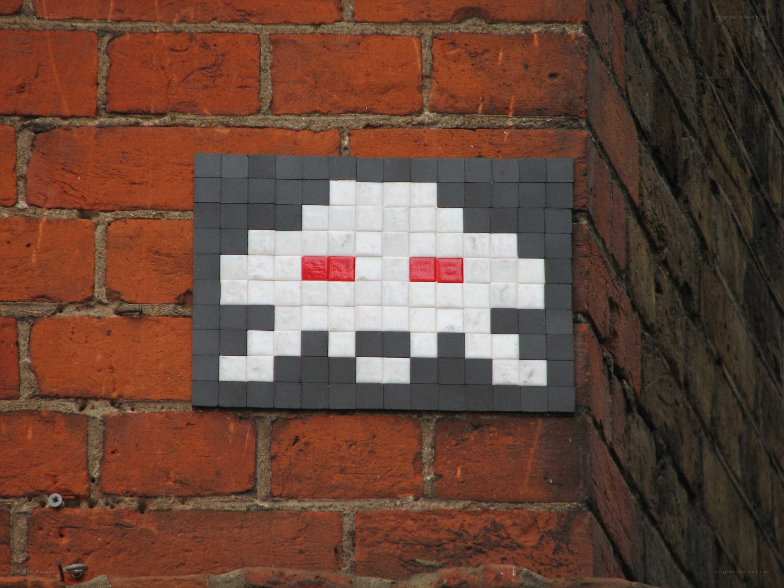 pixel art alien on brick wall