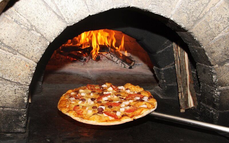 Pizza baking in a wood-fired oven